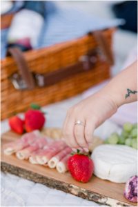 bride showing ring while making charcuterie