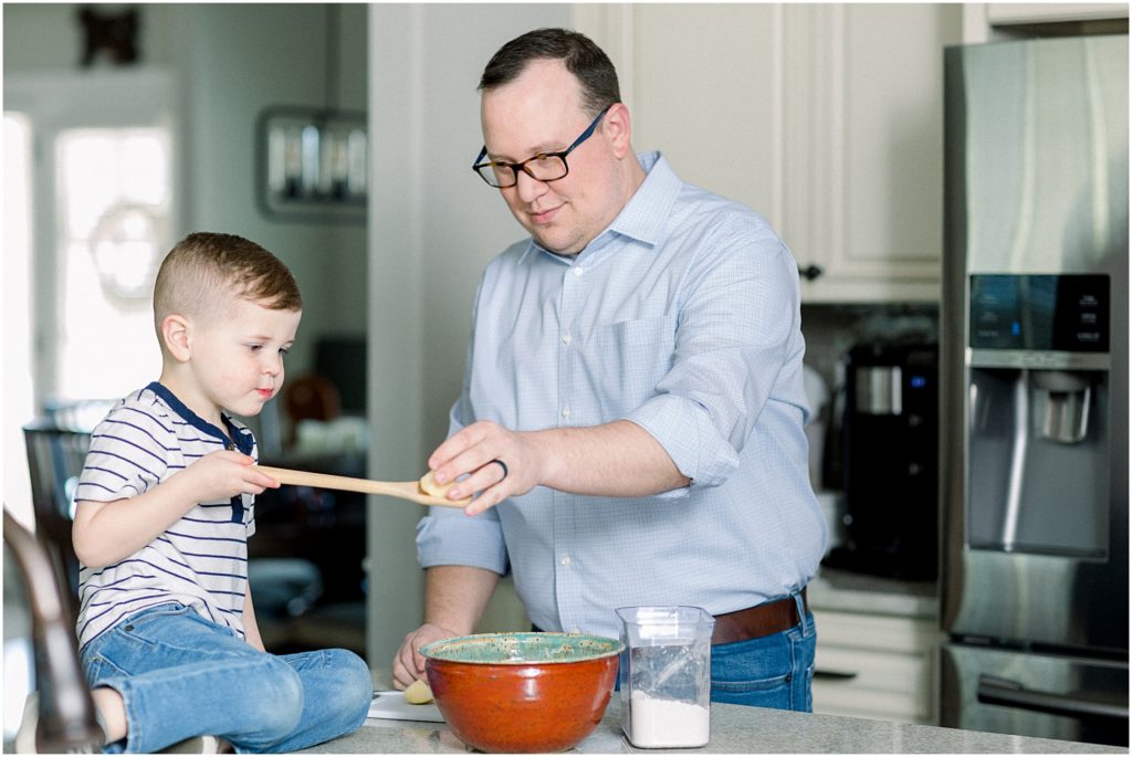 Dad and son cooking in the kitchen together in Newnan, Georgia during a family session.