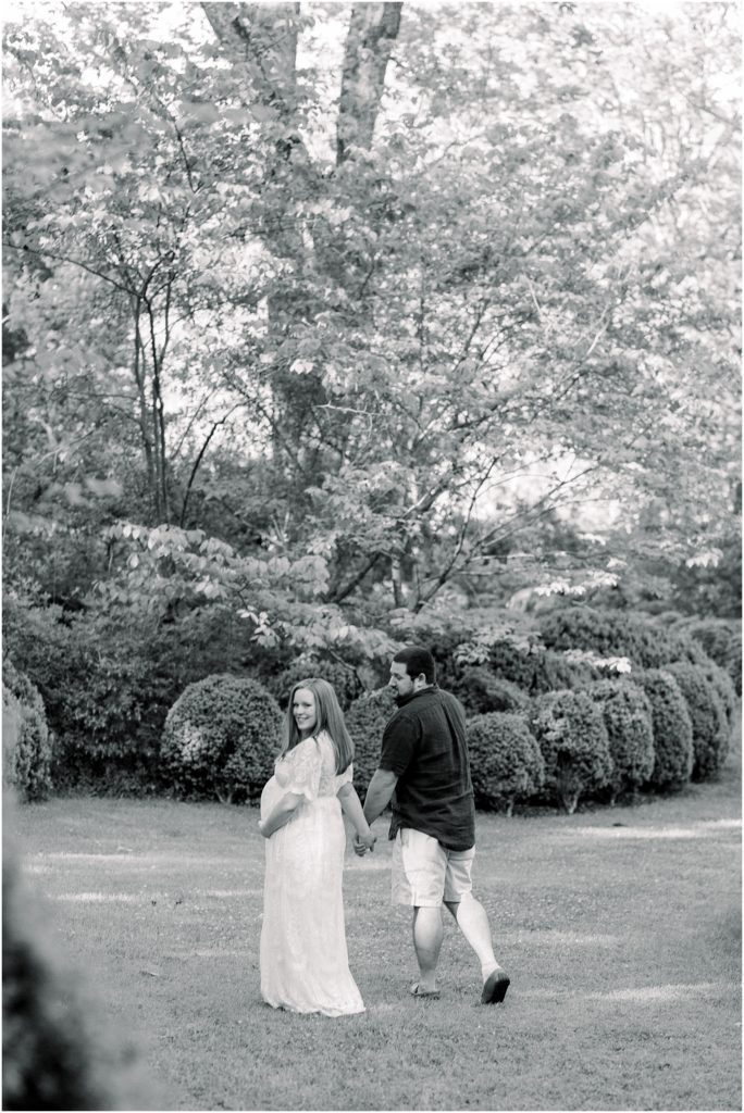 A couple walking through the field during their Maternity session at Meadowlark 1939