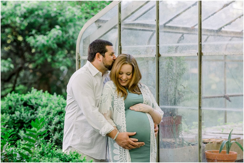 Couple by greenhouse during maternity session in Meadowlark 1939