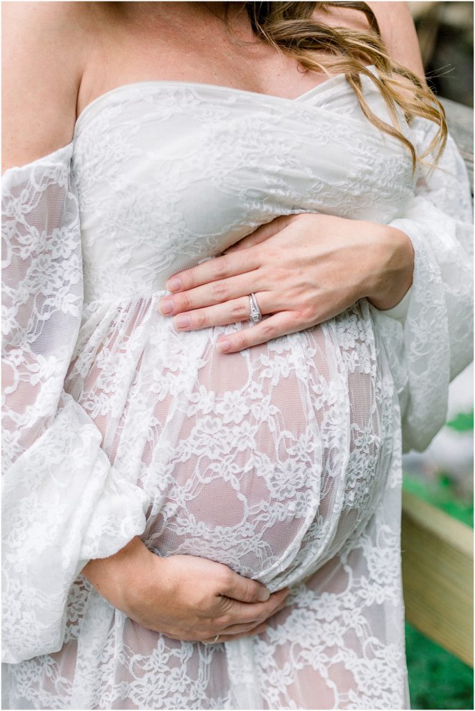 Mom to be holding belly during maternity photos